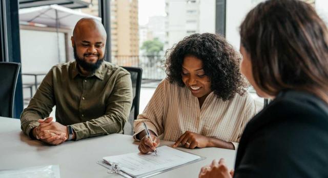 Tratamiento contable de un contrato de compraventa por tramos. Imagen de una pareja cerrando un contrato inmobiliario