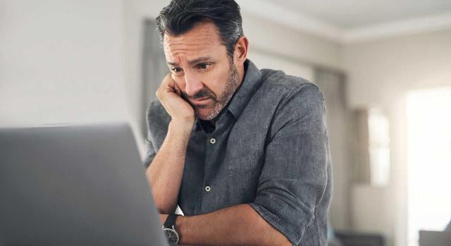 Errores graves en la contabilidad de una empresa que distorsionan la imagen fiel de sus cuentas. Imagen de un hombre sentado con un ordenador con cara de preocupación