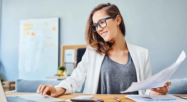 Contable Contable. Mujer trabajando sonriente con su portátil y unos documentos