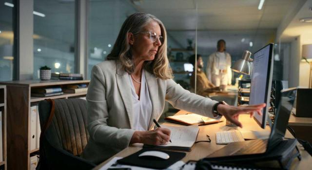 Sobre la información que hay que incluir en la memoria sobre activos y pasivos derivados de contratos por ventas de bienes y prestación de servicios. Imagen de una mujer trabajando en su oficina ya de noche