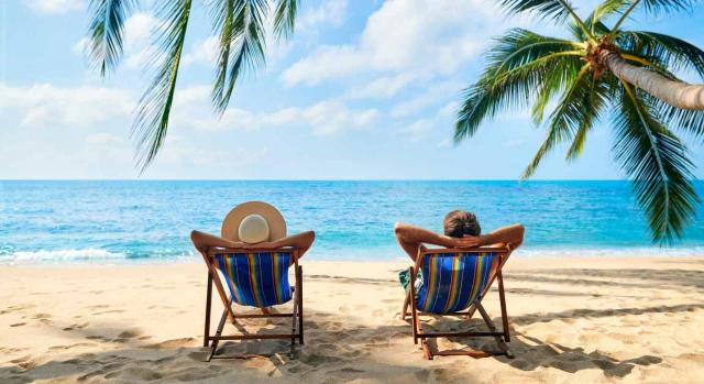 El trabajo del contable y las vacaciones El trabajo del contable y las vacaciones. Imagen de pareja relajándose sentados en hamacas frente al mar